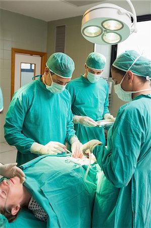 serious surgeon with mask - Female patient lying on operating table Stock Photo - Premium Royalty-Free, Code: 6109-06195844