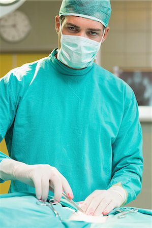 Close up of a serious surgeon opening a patient Stock Photo - Premium Royalty-Free, Code: 6109-06195861