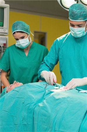 Surgeon opening a patient Foto de stock - Sin royalties Premium, Código: 6109-06195864