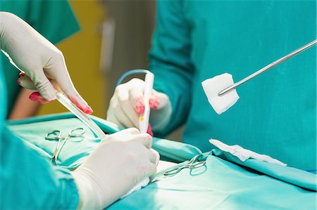 Close up of a surgeon holding surgical tools Stock Photo - Premium Royalty-Free, Code: 6109-06195872