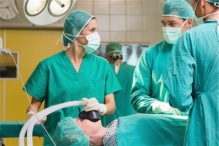 serious surgeon with mask - Surgeon looking at a nurse Stock Photo - Premium Royalty-Free, Code: 6109-06195818