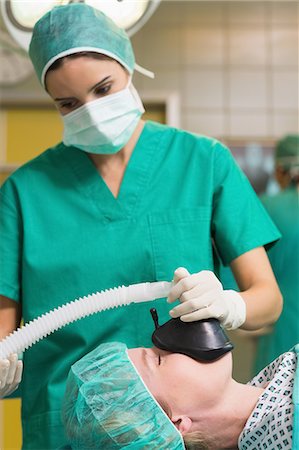 surgeon mask male - Nurse looking at the oxygen tube Stock Photo - Premium Royalty-Free, Code: 6109-06195820