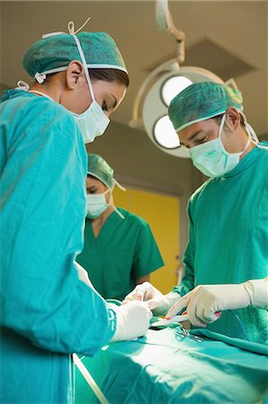 simsearch:6109-06195826,k - Serious surgeons operating a patient Stock Photo - Premium Royalty-Free, Code: 6109-06195836