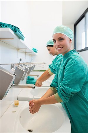 Nurse washing hands while smiling Stock Photo - Premium Royalty-Free, Code: 6109-06195953