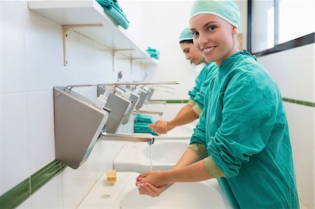 Surgeon washing hands while looking at camera Stock Photo - Premium Royalty-Free, Code: 6109-06195954