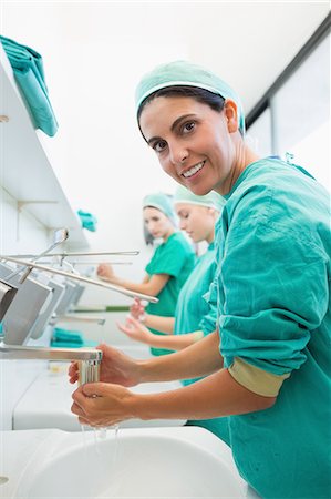 sterilizer - Surgeon rinsing hands while looking at camera Stock Photo - Premium Royalty-Free, Code: 6109-06195963