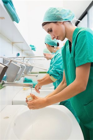 Close up of surgeons brushing hands under water Stock Photo - Premium Royalty-Free, Code: 6109-06195960