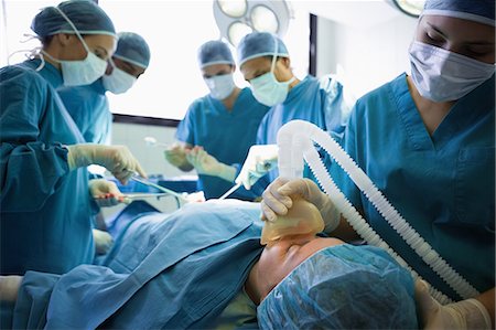 surgery tools - Unconscious patient being operated by surgeons Stock Photo - Premium Royalty-Free, Code: 6109-06195970