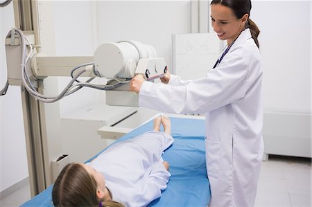 equipamiento médico - Female doctor holding a radiography machine over a patient Foto de stock - Sin royalties Premium, Código: 6109-06195989