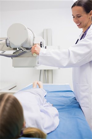 simsearch:6109-08434624,k - Smiling female doctor doing a radiography on a patient Stock Photo - Premium Royalty-Free, Code: 6109-06195990