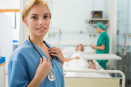 Blonde nurse smiling while standing up Foto de stock - Sin royalties Premium, Código: 6109-06195912