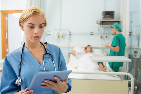 Blonde nurse holding a tablet computer Foto de stock - Sin royalties Premium, Código: 6109-06195915