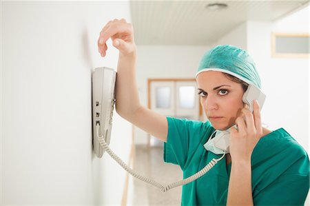 stern doctor - Sad female surgeon using a telephone in a hallway Stock Photo - Premium Royalty-Free, Code: 6109-06196064