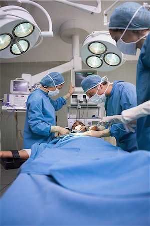 Gruppe von Chirurgen, die auf einer unbewussten männlichen Patienten Stockbilder - Premium RF Lizenzfrei, Bildnummer: 6109-06196016