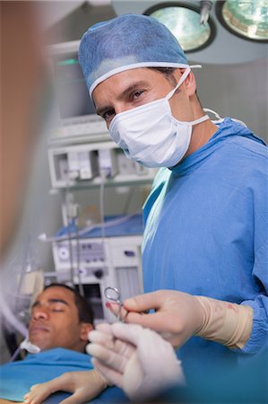 Surgeon holding a scissors during an operation Foto de stock - Sin royalties Premium, Código: 6109-06196019