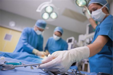 Female surgeon taking a surgical scissors on a surgical tray Foto de stock - Sin royalties Premium, Código: 6109-06196031