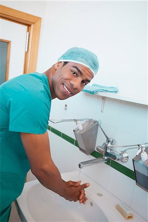 Smiling male surgeon washing his hands Stock Photo - Premium Royalty-Free, Code: 6109-06196034