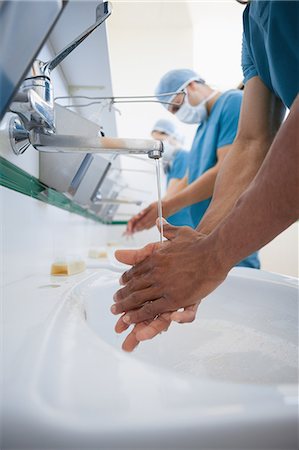 scrubbing - Surgeons washing their hands with masks Stock Photo - Premium Royalty-Free, Code: 6109-06196039