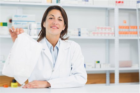 simsearch:6109-06196195,k - Smiling pharmacist woman holding a prescription Stock Photo - Premium Royalty-Free, Code: 6109-06196161