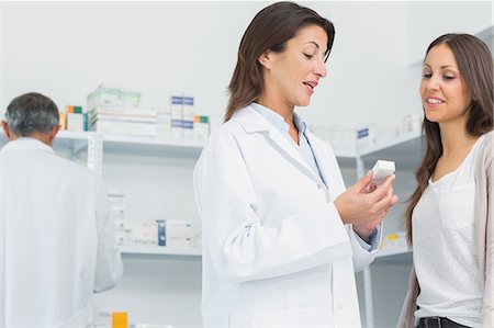 pharmaceutics - Pharmacist talking to a customer while holding pills Foto de stock - Sin royalties Premium, Código: 6109-06196164