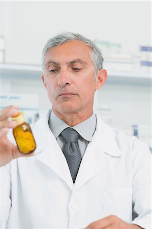 simsearch:6109-06196195,k - Pharmacist holding a bottle full of pills Stock Photo - Premium Royalty-Free, Code: 6109-06196170