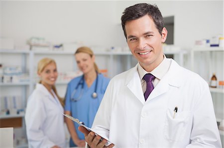 remedy - Pharmacist standing in a pharmacy with nurse and doctor Stock Photo - Premium Royalty-Free, Code: 6109-06196100