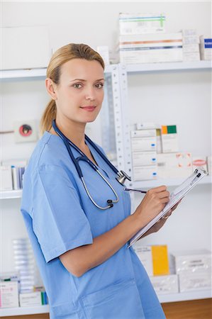 Infirmière dans une pharmacie tenant un bloc-notes Photographie de stock - Premium Libres de Droits, Code: 6109-06196105