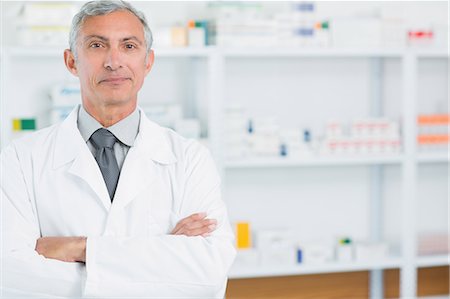 simsearch:6109-06196164,k - Pharmacist with his arms folded standing in a pharmacy Stock Photo - Premium Royalty-Free, Code: 6109-06196120