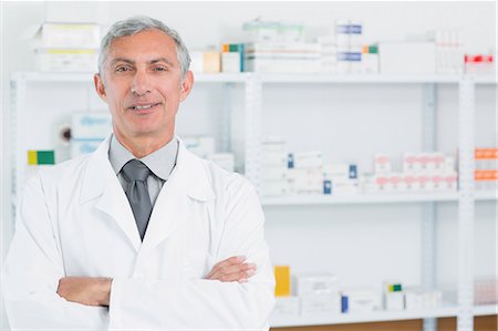 simsearch:6109-06196218,k - Pharmacist standing in a pharmacy with his arms crossed Stock Photo - Premium Royalty-Free, Code: 6109-06196122