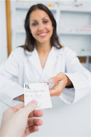 simsearch:6109-06196216,k - Smiling pharmacist receiving a prescription from a customer Stock Photo - Premium Royalty-Free, Code: 6109-06196243