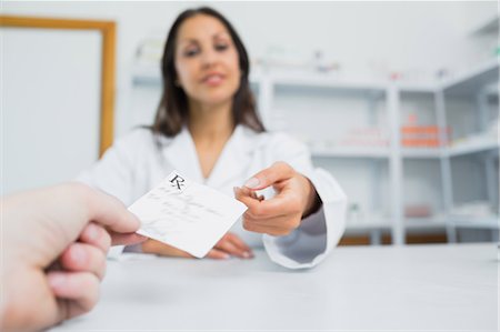 simsearch:6109-06196218,k - Female pharmacist receiving a paper from a customer Stock Photo - Premium Royalty-Free, Code: 6109-06196240