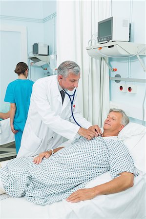 simsearch:6109-06196338,k - Doctor auscultating a male patient in a bed ward Stock Photo - Premium Royalty-Free, Code: 6109-06196258