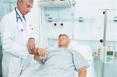 Doctor measuring the pulse of a patient Foto de stock - Sin royalties Premium, Código: 6109-06196264