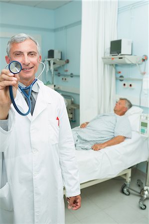 doctors inside the patients room photo - Smiling doctor with his stethoscope Stock Photo - Premium Royalty-Free, Code: 6109-06196277