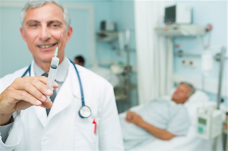 doctor and senior male patient - Doctor with an injection in his hands in a room Stock Photo - Premium Royalty-Free, Code: 6109-06196294