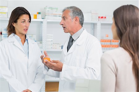 disease - Pharmacist talking to a colleague in front of a patient Stock Photo - Premium Royalty-Free, Code: 6109-06196200