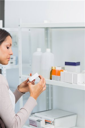 Woman looking at a box of pills Stock Photo - Premium Royalty-Free, Code: 6109-06196213