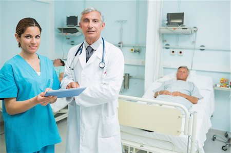 simsearch:6109-06196265,k - Male doctor and female nurse standing in a room while holding a tactile tablet Stock Photo - Premium Royalty-Free, Code: 6109-06196349