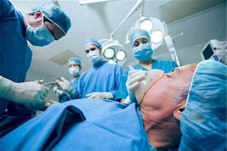 Équipe de chirurgie dans un théâtre d'opération d'un patient Photographie de stock - Premium Libres de Droits, Code: 6109-06196383