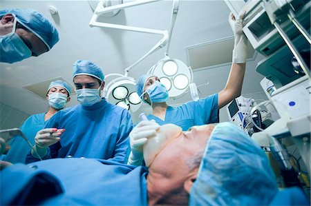 Surgical team in an operating theater operating a patient Stock Photo - Premium Royalty-Free, Code: 6109-06196387