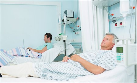 Two male patients lying on hospital beds Foto de stock - Sin royalties Premium, Código: 6109-06196302