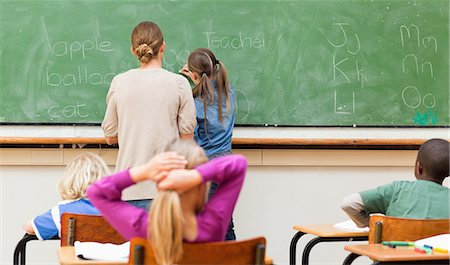 photography chalkboard teacher - Back view of teacher and pupil writing on blackboard Stock Photo - Premium Royalty-Free, Code: 6109-06196456