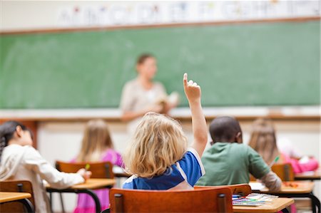 Boy raising his finger during lesson Foto de stock - Sin royalties Premium, Código: 6109-06196405