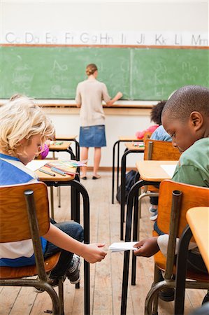 simsearch:6109-06196557,k - Back view of schoolboy giving his schoolfellow a letter Stock Photo - Premium Royalty-Free, Code: 6109-06196432