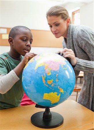 Teacher explaining globe to a student Foto de stock - Sin royalties Premium, Código: 6109-06196557