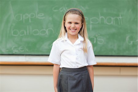 simsearch:6109-06007620,k - Girl standing in front of blackboard Foto de stock - Royalty Free Premium, Número: 6109-06196567