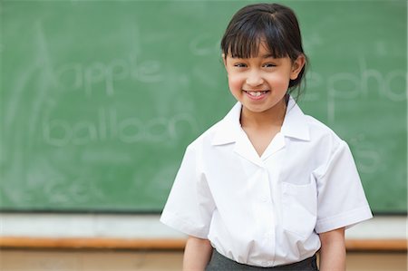 Fille à l'école en uniforme devant le tableau noir Photographie de stock - Premium Libres de Droits, Code: 6109-06196570