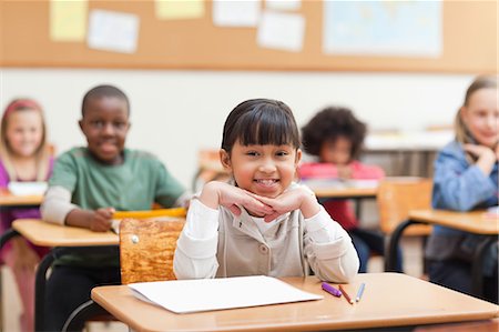 simsearch:6109-06196569,k - Smiling pupil sitting at her desk Foto de stock - Sin royalties Premium, Código: 6109-06196504