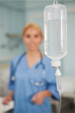 Focus on an intravenous drip next to a nurse Stock Photo - Premium Royalty-Free, Code: 6109-06684672