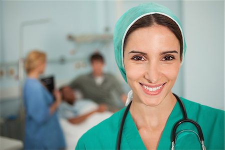 doctor scrubs patient smile - Nurse smiling next to a medical bed Stock Photo - Premium Royalty-Free, Code: 6109-06684686